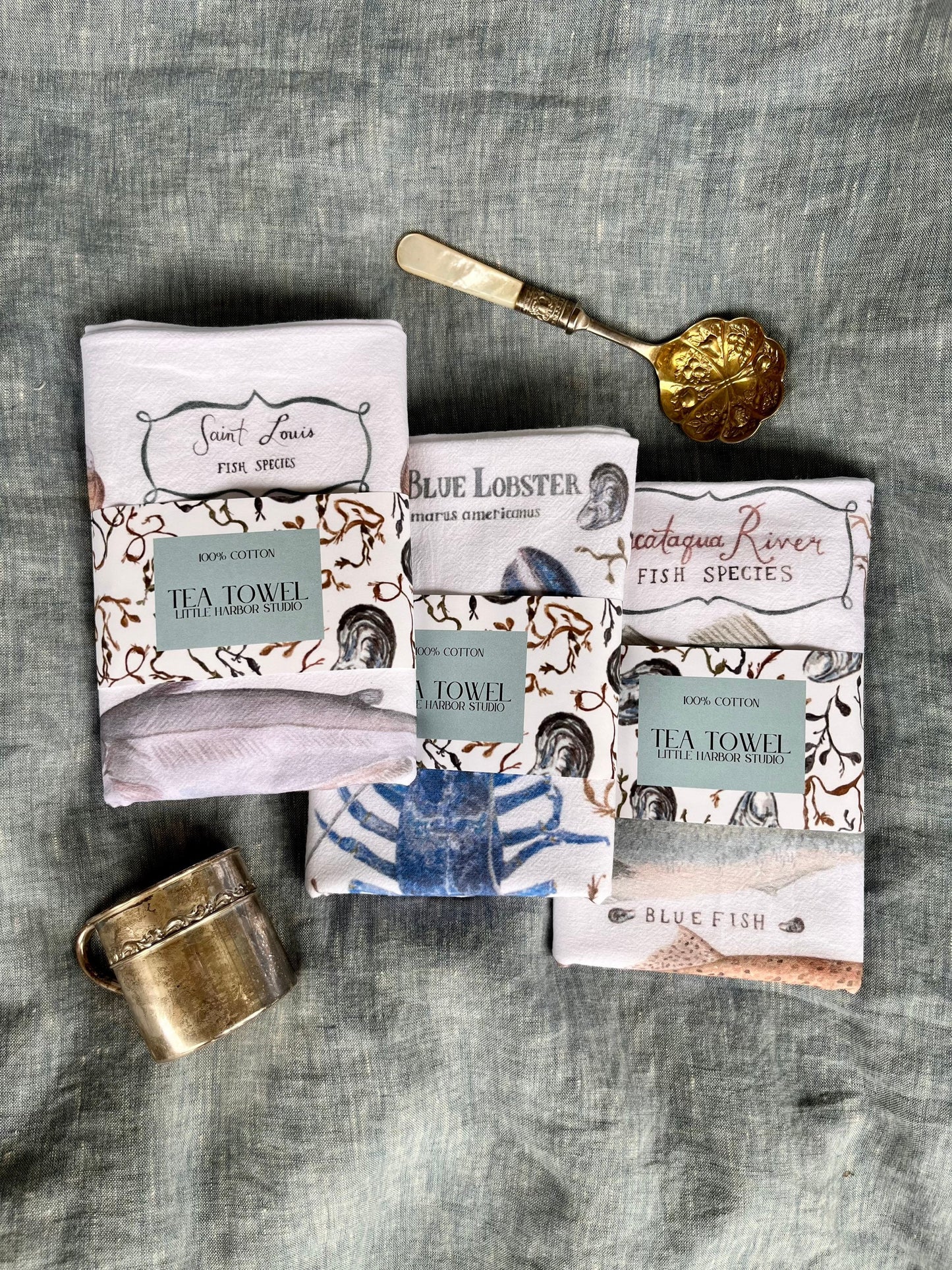 Hand painted tea towel with Piscataqua River fish including Striped Bass, Bluefish, Brown Trout & Polluck with hand painted seaweed and Atlantic mussels shells.