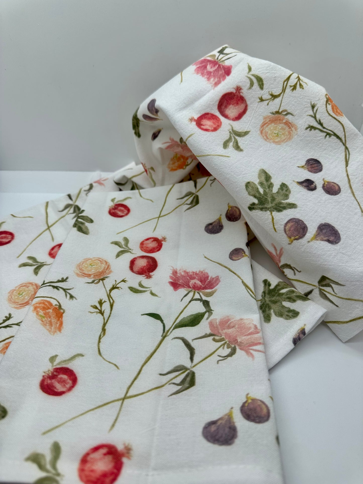 Madeleine tea towel with vibrant hand-painted watercolor pattern of peonies, ranunculus, figs and pomegranates.