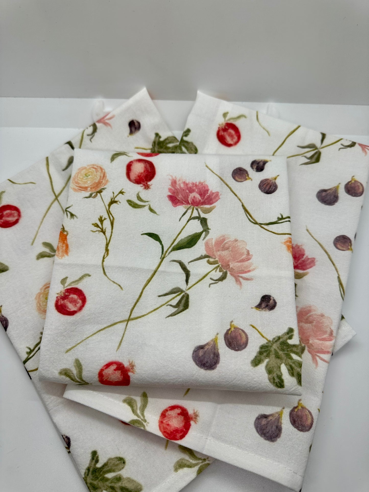 Madeleine tea towel with vibrant hand-painted watercolor pattern of peonies, ranunculus, figs and pomegranates.